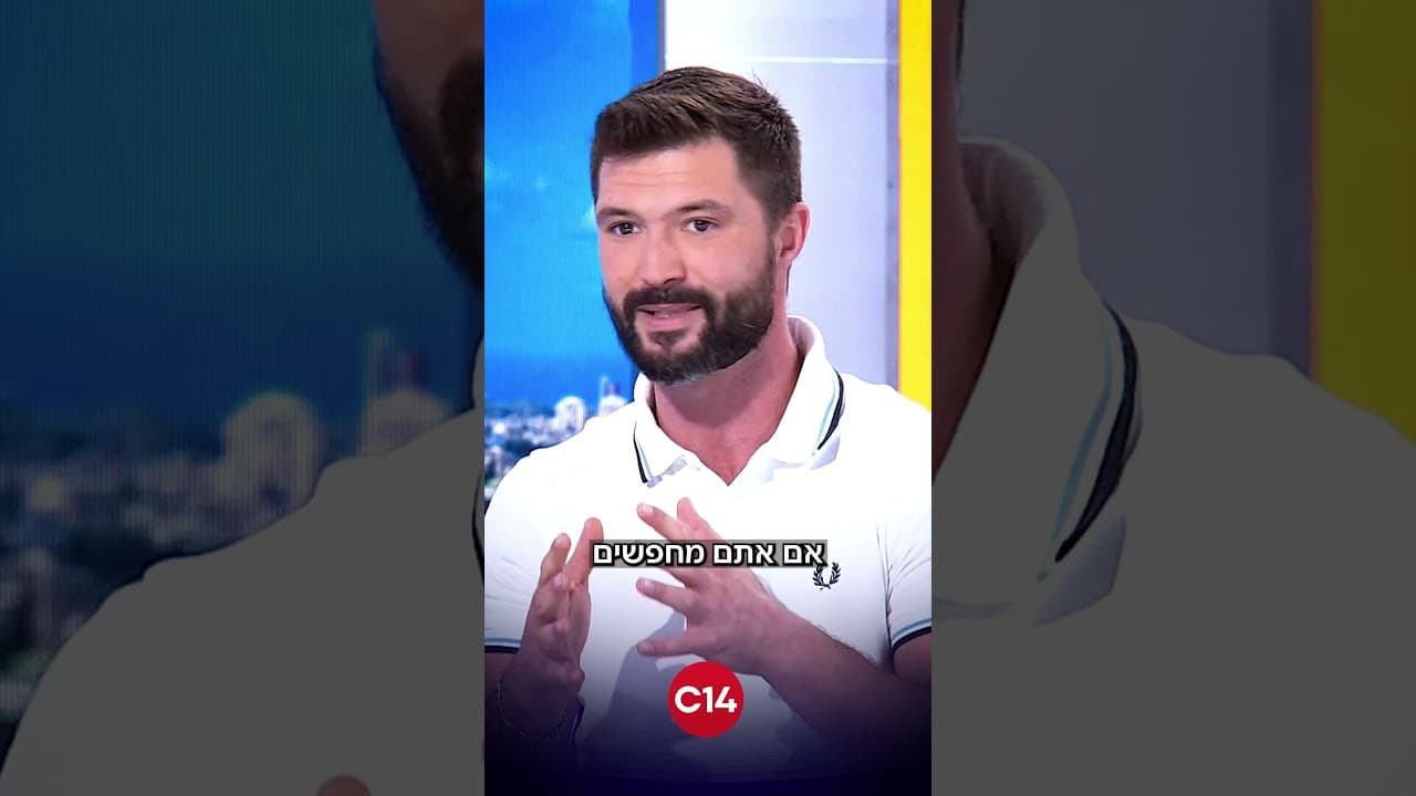 פריים מהקטע בערוץ 14: מקסים גומברג מדבר עם הידיים באולפן, עם סמל C14