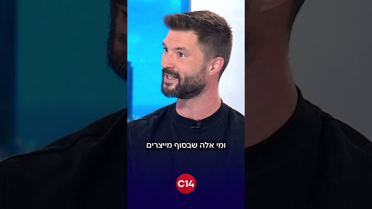 פריים מהקטע בערוץ 14: מקסים גומברג בחולצה שחורה באולפן, עם סמל C14